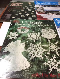 crocheted christmas ornaments and snowflakes are on the table next to each other