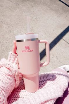 a pink starbucks cup sitting on top of a blanket