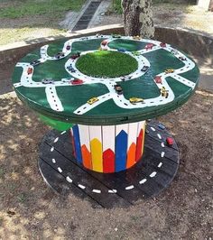 a toy train track table in the middle of a park