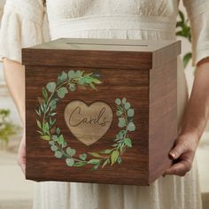 a person holding a wooden box with a heart on it