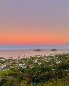 the sunset is setting over an island in the middle of the ocean with houses on it