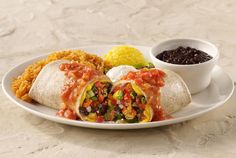 a burrito with salsa, beans and rice on a plate