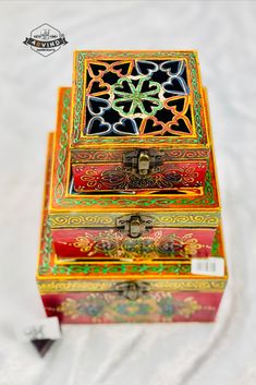 two colorful boxes sitting on top of a white sheet