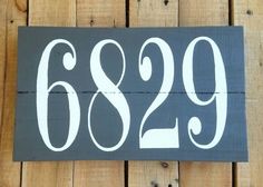 a black and white sign with the number 669 on it's side against a wooden wall