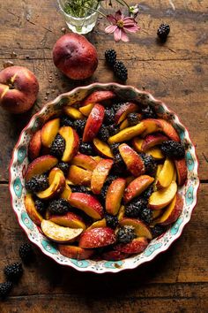 a bowl filled with fruit sitting on top of a wooden table