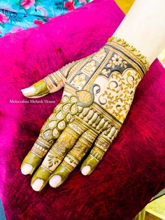 a woman's hand decorated with hennap and gold designs on her hands