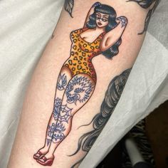 a woman with tattoos on her arm and leg