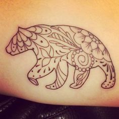 a tattoo on the leg of a woman with an animal design on it's thigh