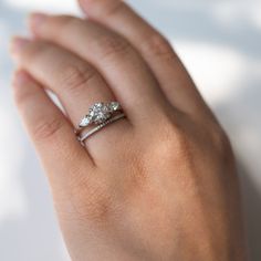 a woman's hand with two diamond rings on it