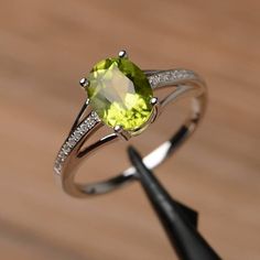 It is a natural peridot ring. The main stone is 7mm*9mm oval cut, weight about 1.99 carats.The basic metal is sterling silver and plated with rhodium.To change the metal to a solid gold (white/rose) or platinum is also available, please ask for a quotation if you want.You can also go to my shop Home for more elegant rings: https://www.etsy.com/shop/godjewelry?ref=hdr_shop_menuMore rings:https://www.etsy.com/shop/godjewelry?ref=l2-shop-header-avatarCustomization is always welcome and please feel Rainbow Topaz Ring, Peridot Engagement Rings, Elegant Rings, August Birthstone Ring, June Birthstone Ring, August Birthstone, Peridot Ring, Engagement Rings Oval, Ring Oval