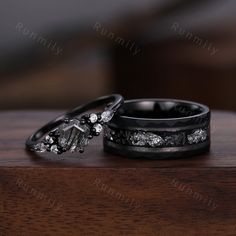 two wedding rings sitting on top of a wooden table next to each other with diamonds in them