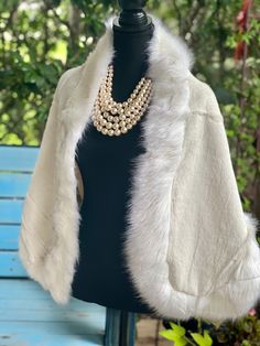 Introducing our luxurious White Winter Cape, the perfect addition to elevate your winter and formal wear. Crafted with trimmed faux fur, this cape exudes elegance and sophistication. The inner fabric is made with a soft and matching satin layer, giving it a polished and refined look. Designed to suit a variety of occasions, this cape is perfect for brides, bridal parties, shows, casual outings, school, office, dates, and parties, making it a versatile and essential piece for your wardrobe. It is suitable for the winter, early spring, and cold autumn seasons. To maintain its exquisite quality, we recommend dry cleaning only. However, you may also hand wash it in cold water and hang to dry. Please note, machine washing is not recommended. Measuring at a free size, with a width of 23.6''/60cm Faux Fur Wedding, Bridal Coat, Winter Cape, Winter Poncho, Faux Fur Cape, Wedding Fur, Cold Autumn, Fur Cape, Bridal Parties