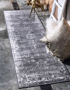 an area rug that is on the ground next to a chair and other items in front of