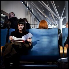 a woman sitting in an airplane reading a book