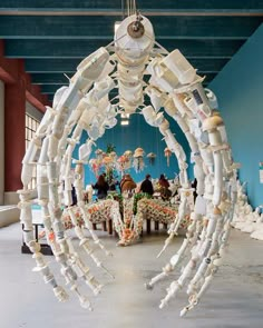 an art installation made out of plastic bottles and other items in a room with blue walls