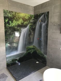 a bathroom with a waterfall mural on the wall