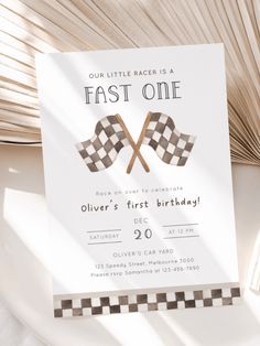 a birthday card with two crossed checkered flags and the words, our little racer is a fast one