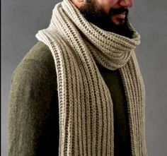 a man wearing a knitted scarf and hat with a beard in front of a gray background