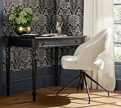 a white chair sitting next to a desk with a potted plant on top of it