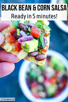 Person's hand is holding a tortilla chip with black bean and corn salsa. Title: Black Bean and Corn Salsa Salsa With Avocado, Bean Corn Salsa, Black Bean And Corn Salsa, Corn Bean Salsa, Black Bean Corn Salsa, Mexican Salsa Recipes, Corn Salsa Recipe, Black Bean And Corn, Black Bean Corn