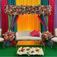 a living room decorated with colorful drapes and flowers