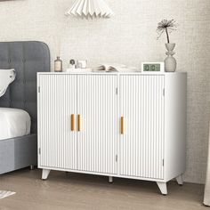 a white cabinet sitting next to a bed in a bedroom