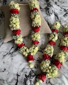 two red and white flowers arranged on a marble surface