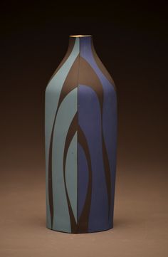 a blue and brown vase sitting on top of a table