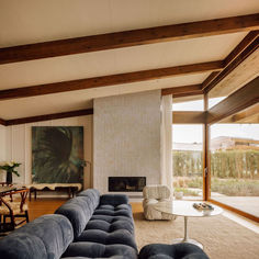 a living room filled with furniture and a fire place in front of a large window