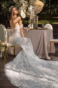 a woman in a wedding dress sitting at a table