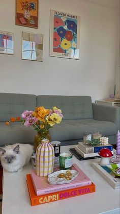 a cat sitting on the coffee table next to books