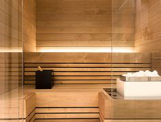 a wooden sauna with glass walls and benches