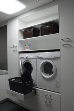 a washer and dryer sitting in a room next to each other on top of cabinets