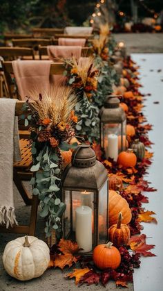 a row of lanterns with fall leaves and pumpkins