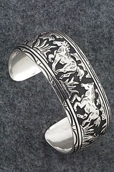 This expertly crafted sterling silver bracelet featuring horses was made by Navajo silversmith Richard Singer. The back is signed R Singer and stamped .925.Size: 5 5/8" (will fit up to a 6 3/4" wrist)Gap: 1 1/8"Width: 1"Free shipping on all orders! We ship with USPS and always include tracking. All orders ship within a day of payment.Returns are accepted up to 30 days after you receive your order. Just send us a message. Our shop offers cash back or store credit. The item must be returned in new Sterling Silver Southwestern Bracelet With Polished Finish, Western Sterling Silver Cuff Bracelet, Western Sterling Silver Bracelets, Western Style Sterling Silver Bangle, Western Style Sterling Silver Cuff Bracelet, Western Style Sterling Silver Bracelets, Western Style Silver Cuff Bracelet Gift, Western Style Silver Cuff Bracelet As A Gift, Western Style Engraved Bracelets For Gifts