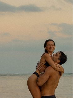 a man and woman hugging on the beach