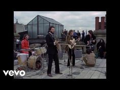 a group of people standing on top of a roof next to each other with musical instruments