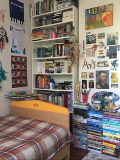 a bed sitting in a bedroom next to a bookshelf filled with lots of books