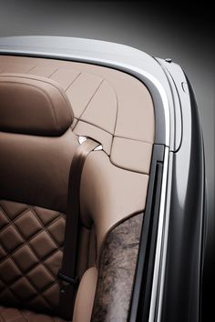 the interior of a car with brown leather and tan stitching on the seat covers