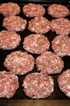 some hamburger patties are cooking on a grill