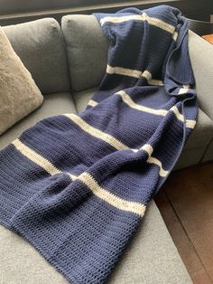 a blue and white crocheted blanket sitting on top of a couch