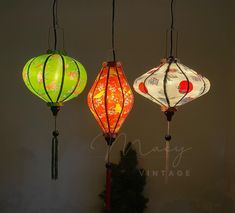 three different colored lanterns hanging from the ceiling