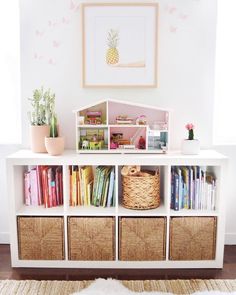 a white shelf with baskets and books on it