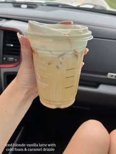 a person holding up a drink in their hand with the words iced blonde vanilla latte with cold foam and caramel drizzle