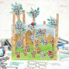 a close up of a card with animals and trees in the background on a table