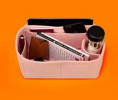 a pink case filled with personal items on top of a yellow background