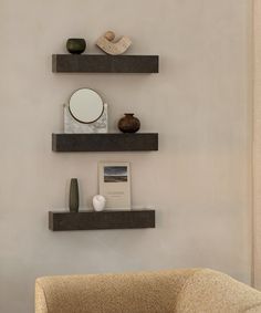 three floating shelves on the wall above a chair