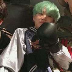 two boys with green hair sitting next to each other