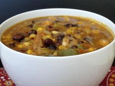 a white bowl filled with soup sitting on top of a red and yellow place mat