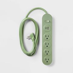 a green power strip sitting on top of a white table next to an electrical outlet